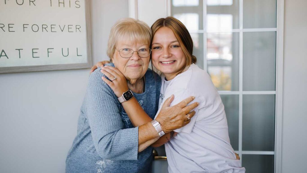 Resident sharing a hug with caregiver at Serenity Villa