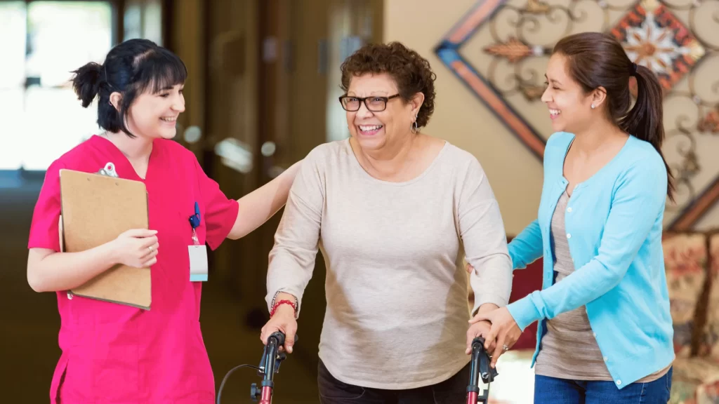 Senior happily assisted by the caregivers in the assisted living facility